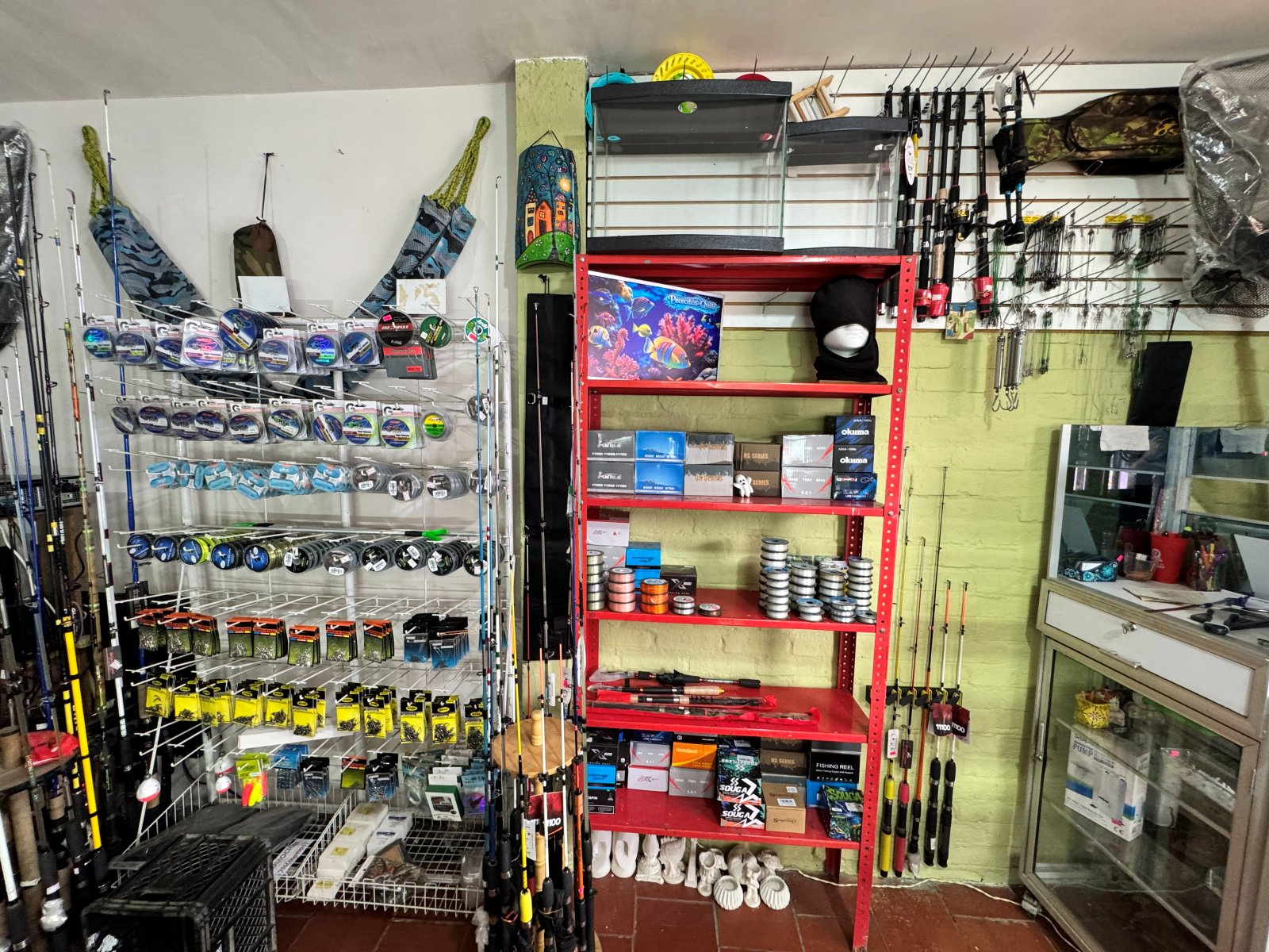 Estantería con carretes, cañas de pescar y accesorios de pesca deportiva